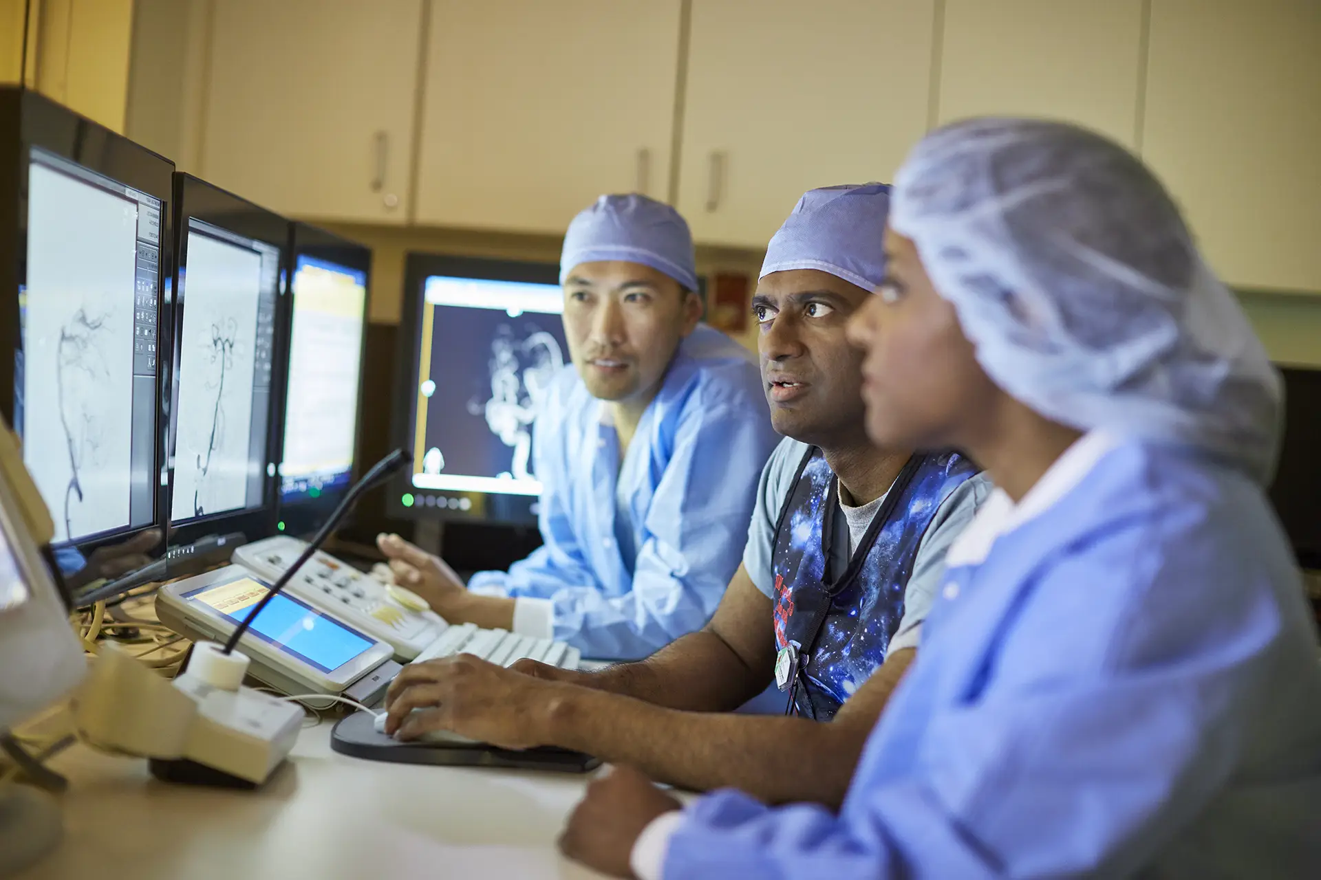Physicians looking at screens and consulting with each other